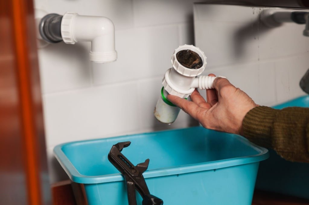 General plumbing services in Salem with a sink trap opened to remove debris and restore drainage